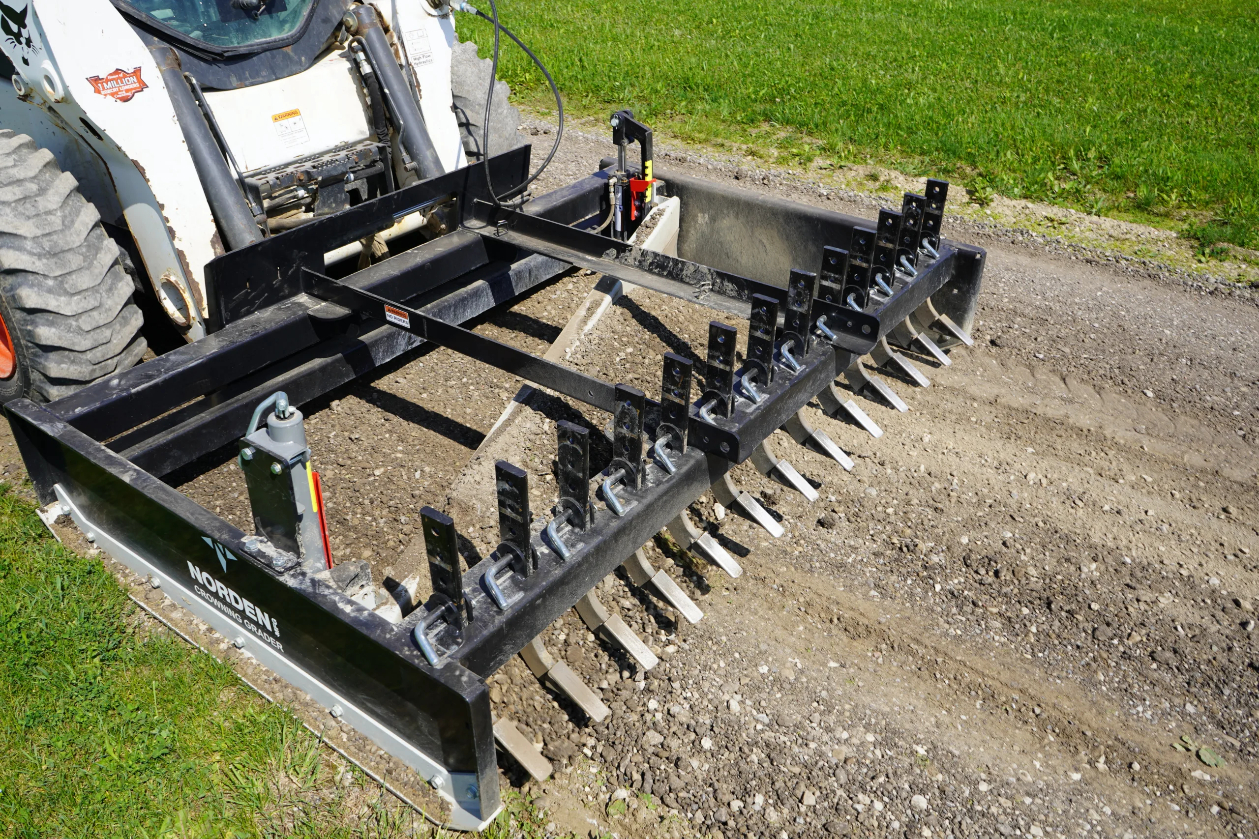 Operator fine-tuning gravel driveway grade for smoother drainage and vehicle travel